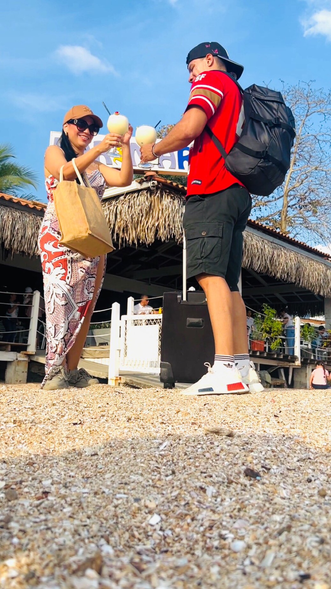 Visitantes brindando con bebidas tropicales frente a Karimar